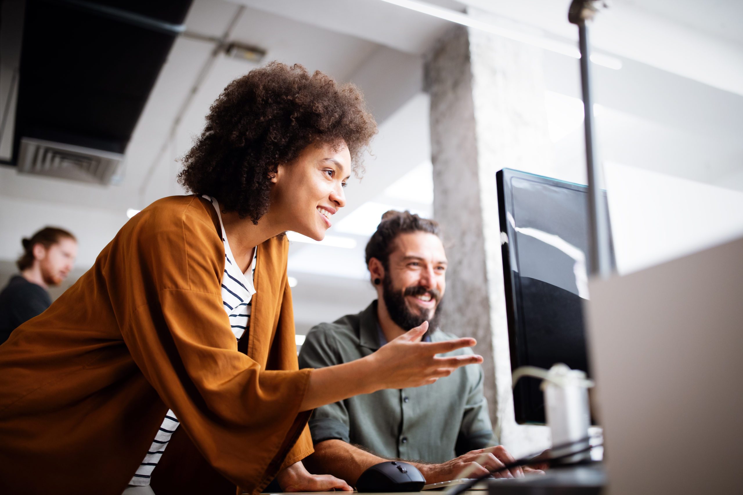 Workers smiling at a computer screen