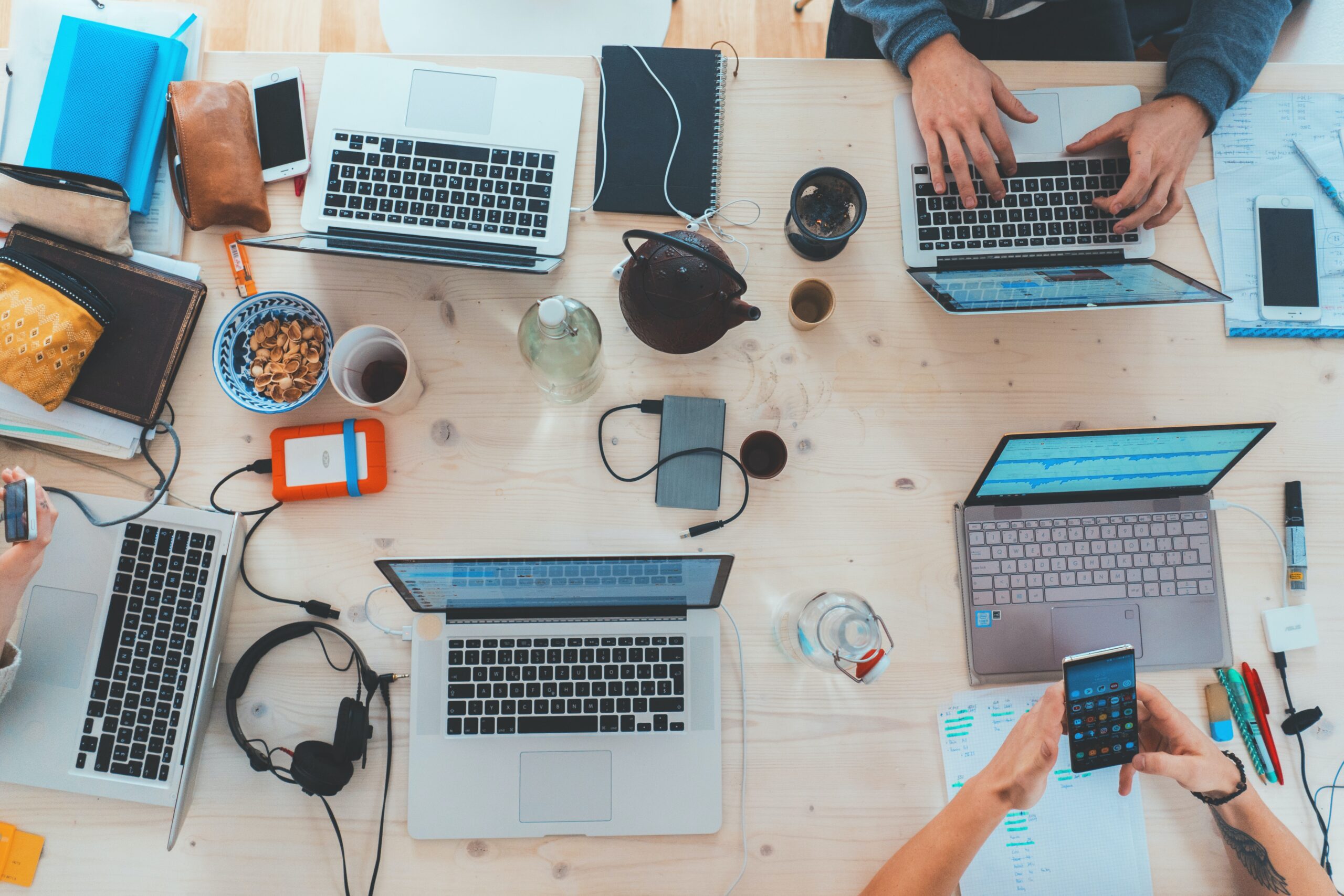 Workers using laptops at communal desk